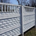 private long white concrete fence outside in green grass